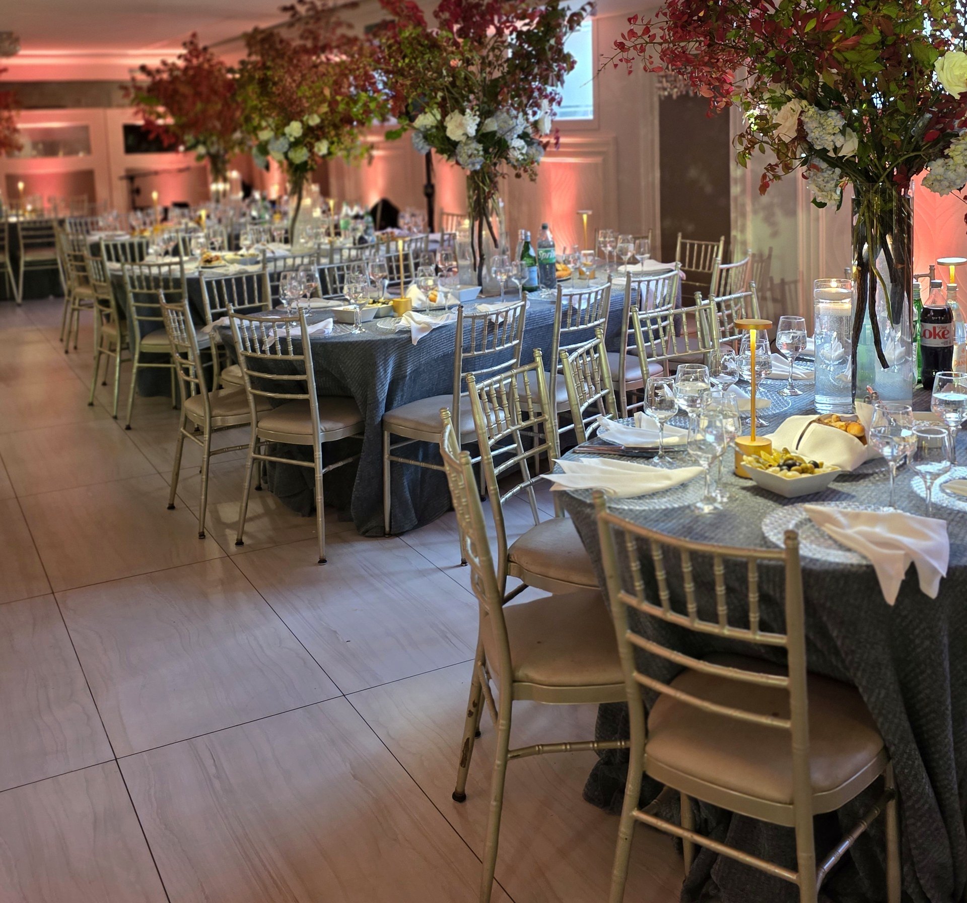 Red maple trees over the tables, the walls lit warm