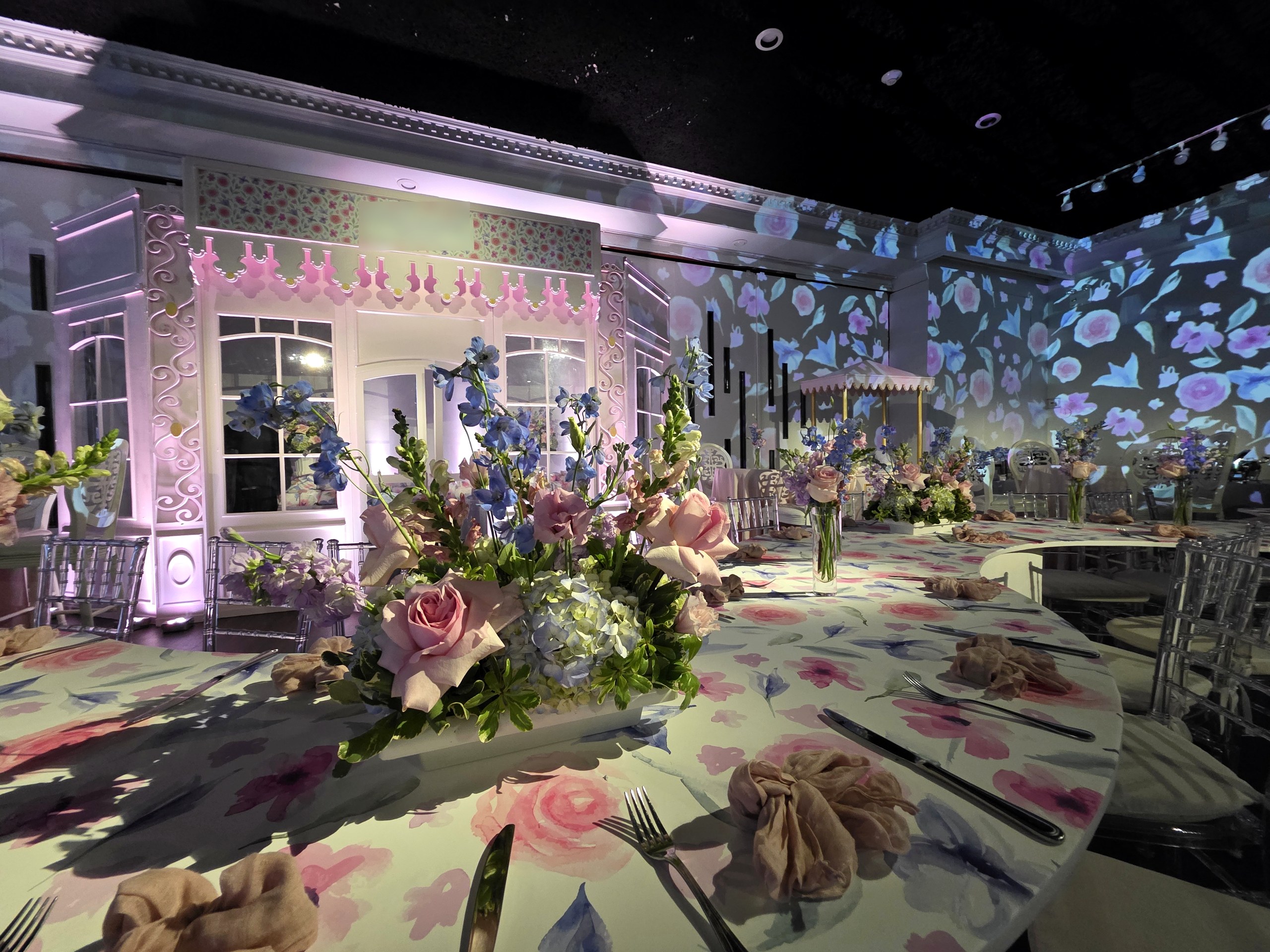 The table under the florals, the storefront behind