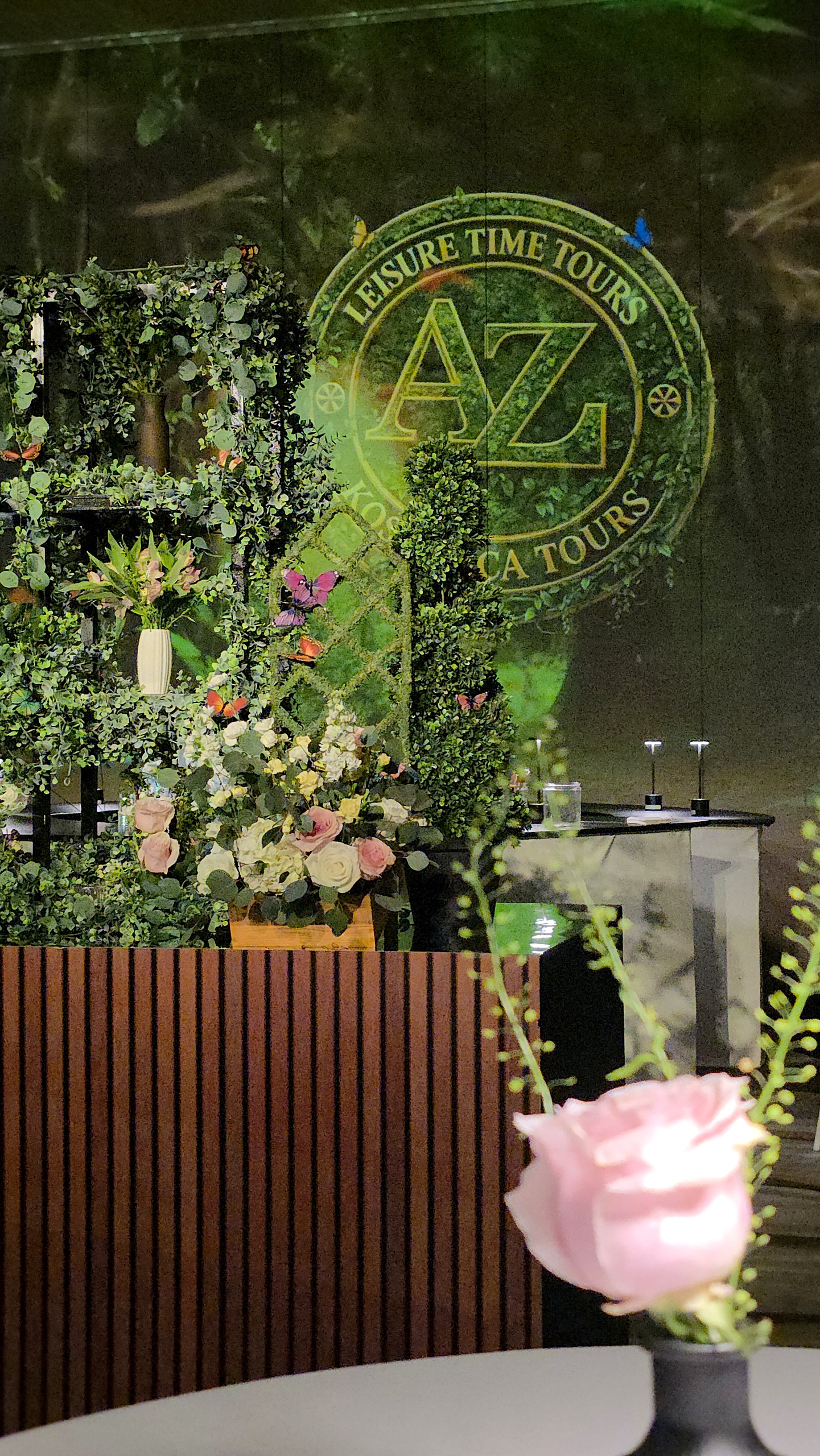 The floral wall and a single rose, the forest projected behind