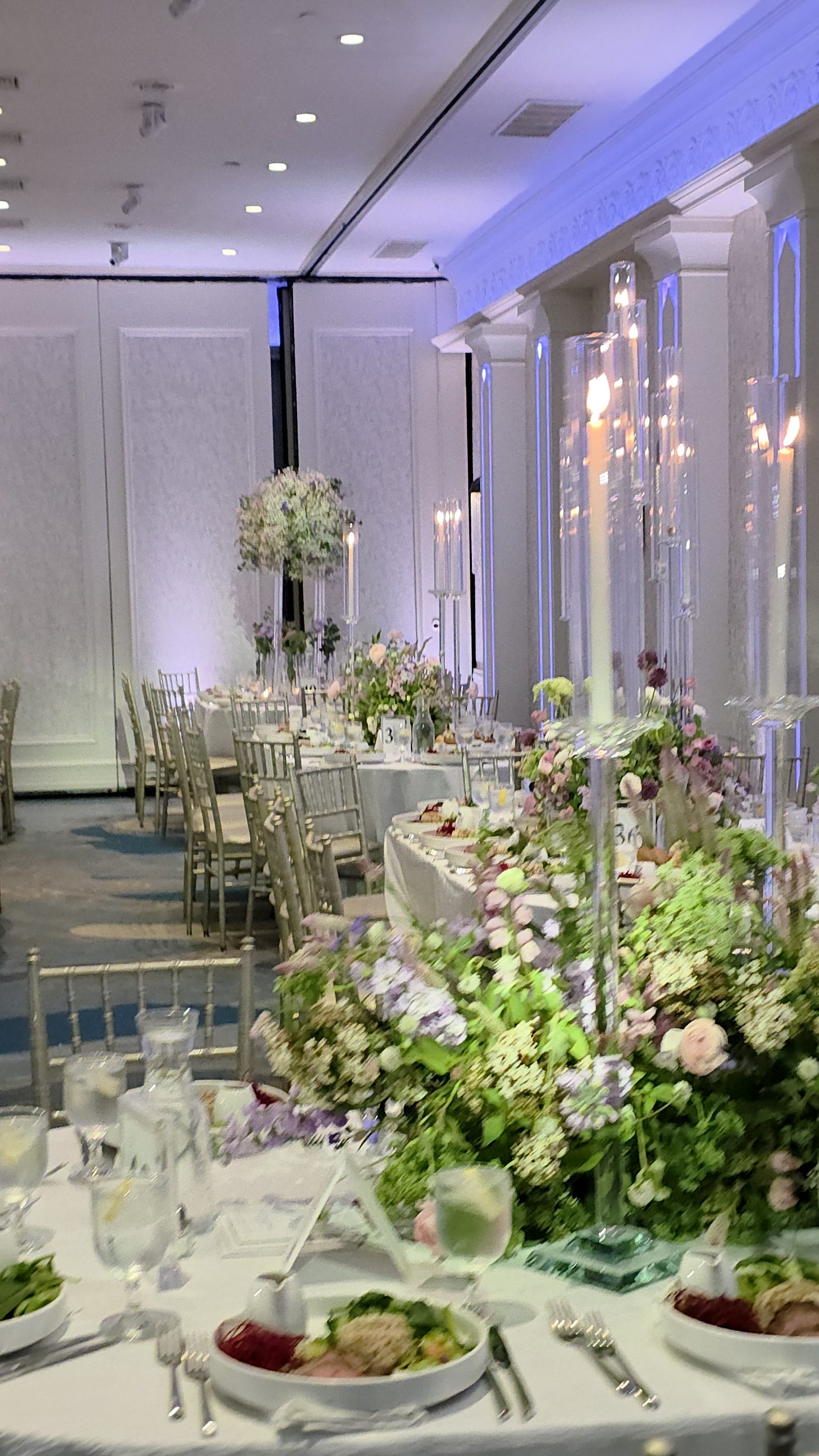 Round tables under tapers, the florals and the lit walls