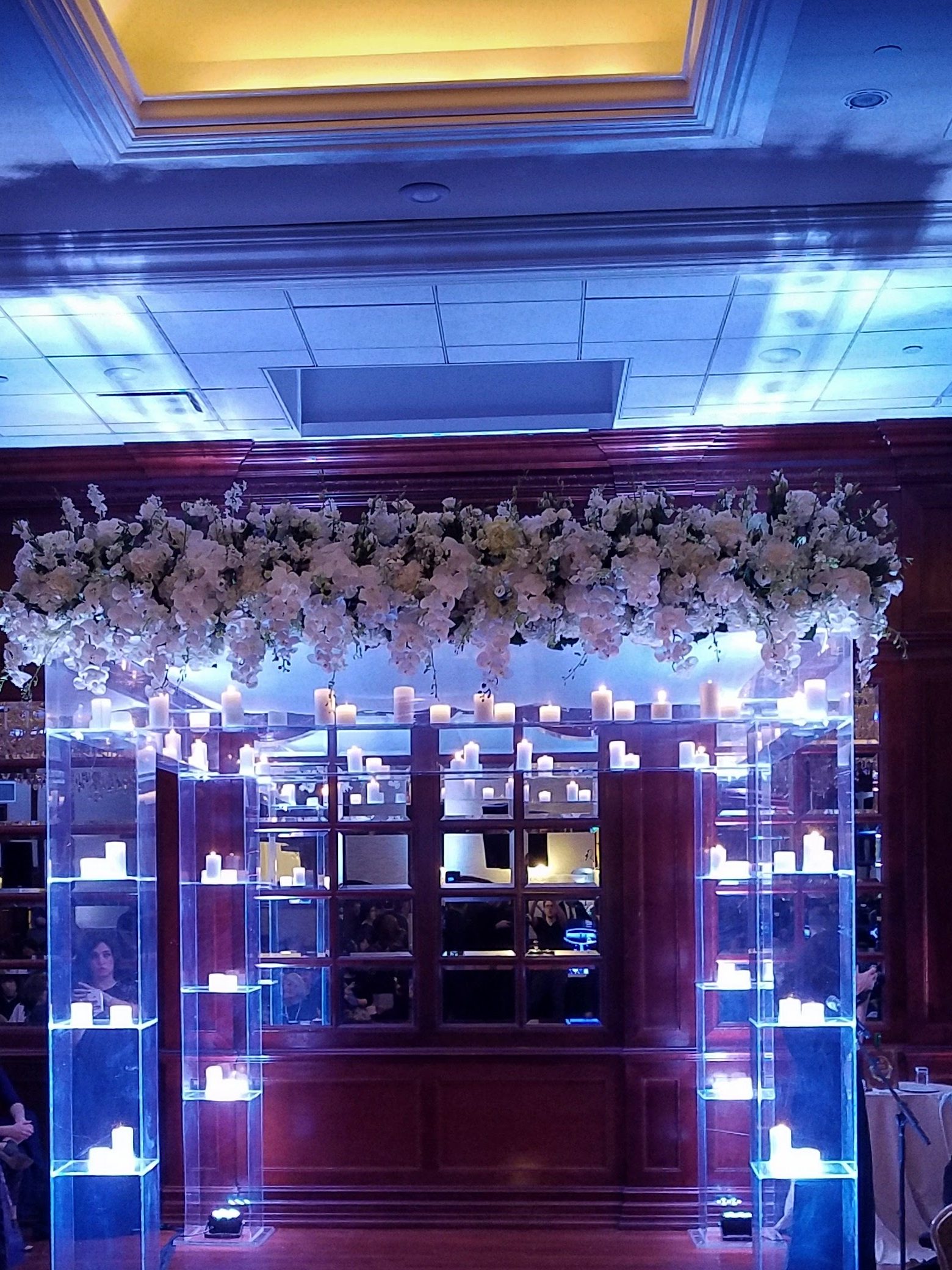 The chuppah of lit columns across the red aisle, the room washed blue