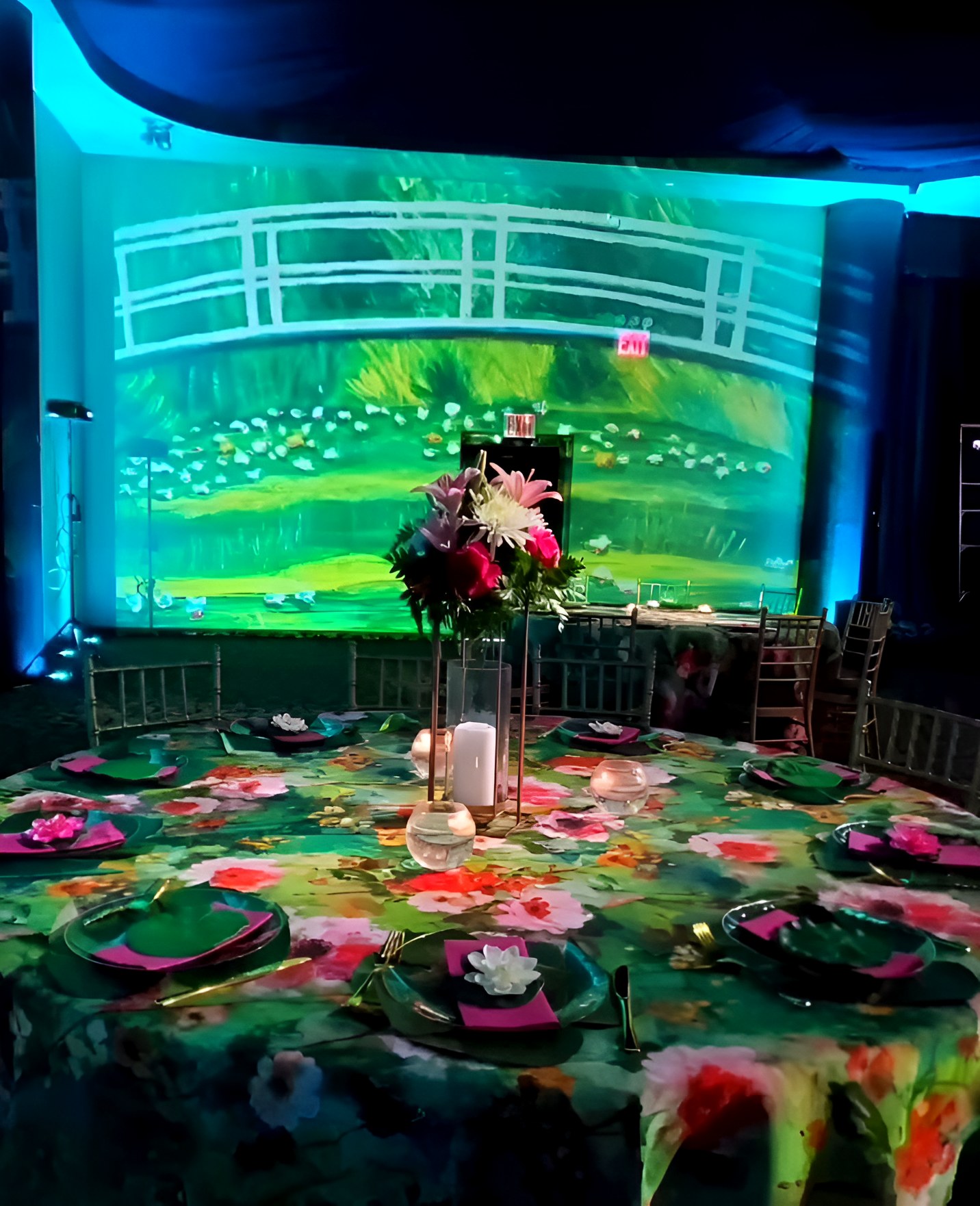 The Monet bridge projected across the back wall, tables set in front