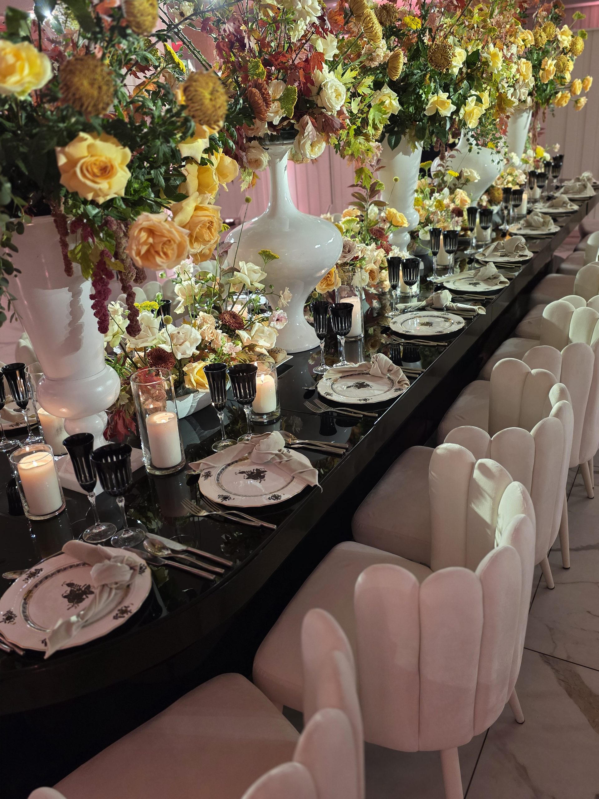 The room: black tables, white scalloped chairs, the roses, the pink-lit walls