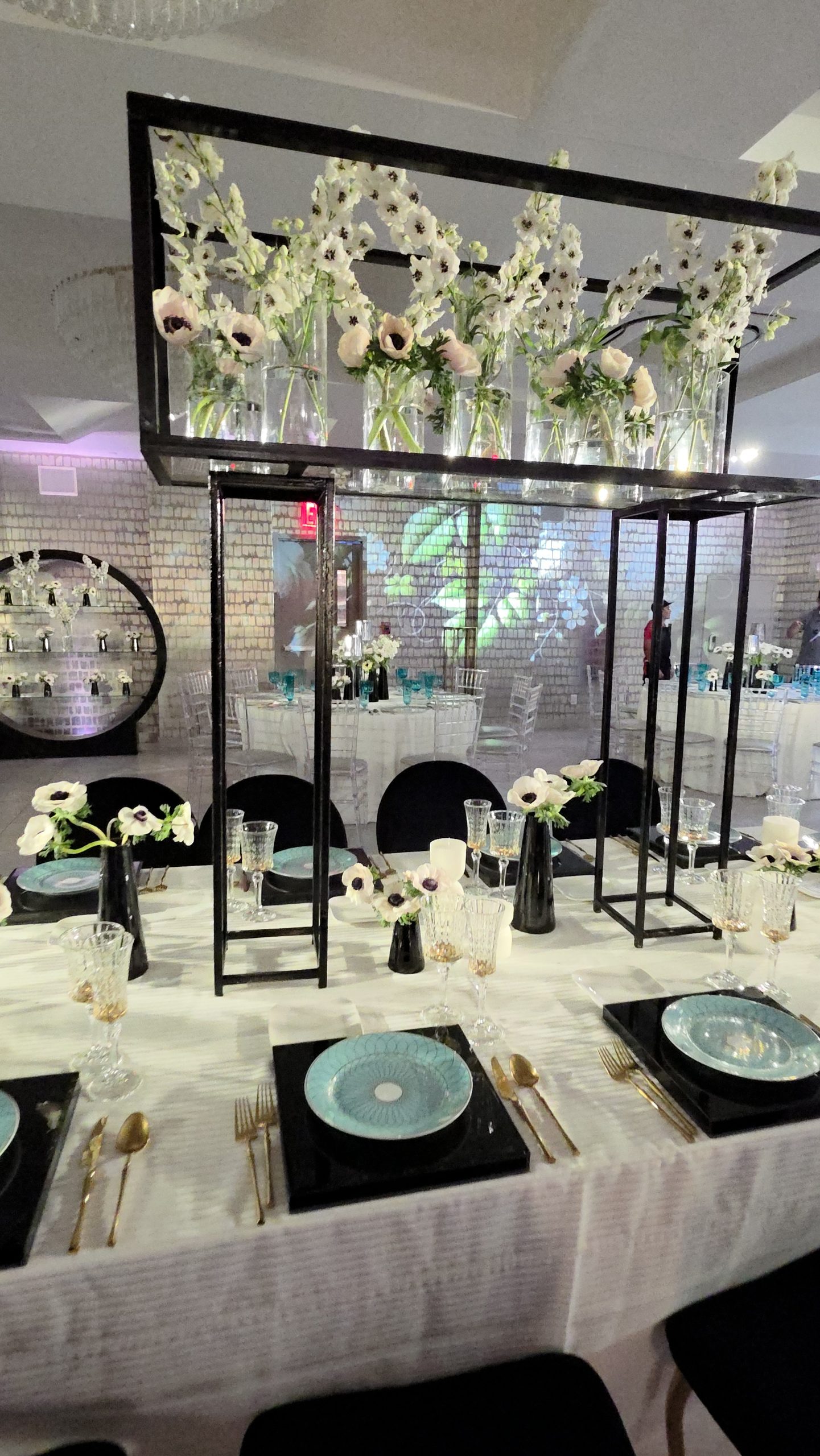 The black frame of white florals over the long table, the projected wall behind