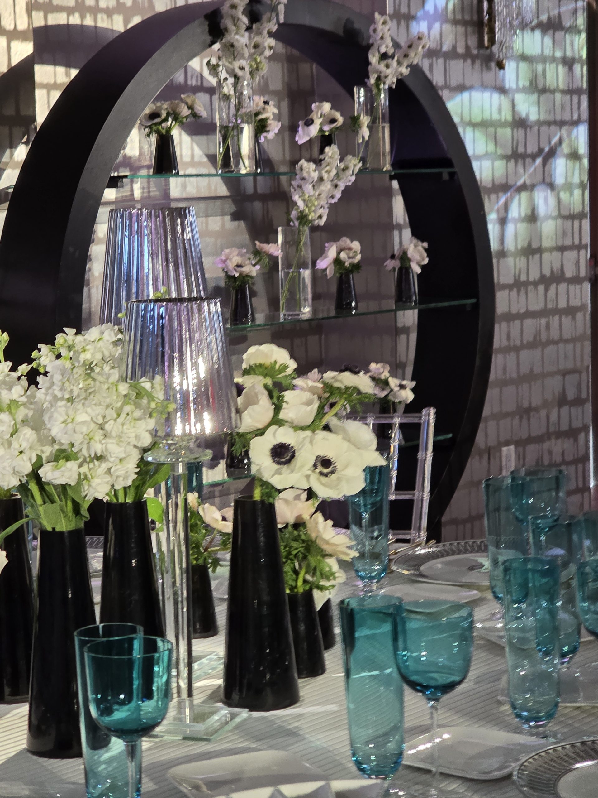 The loft: the projected hydrangea wall, the black frames of florals over the tables, teal glass