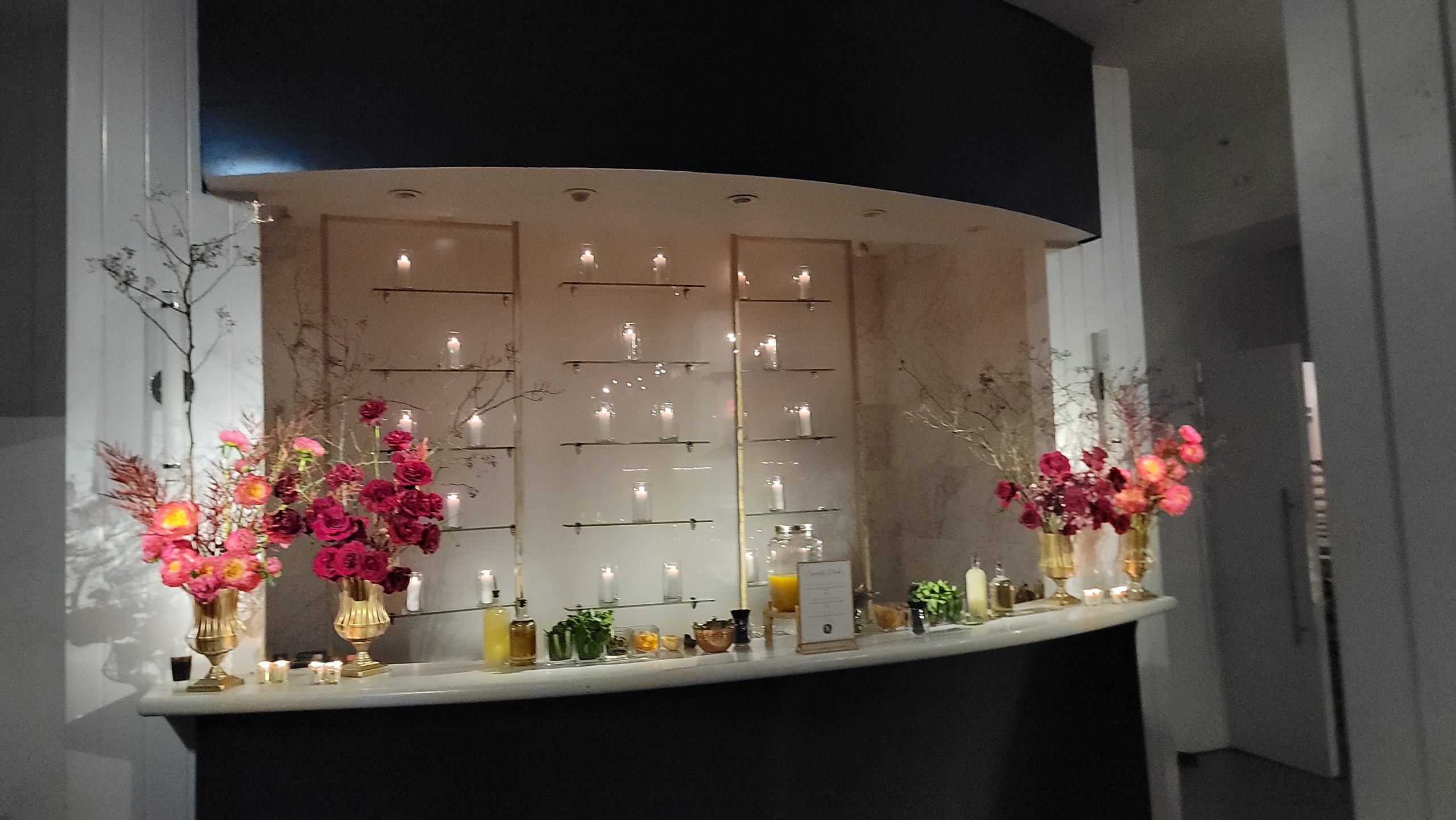 The bar: a wall of small flames in glass, coral florals either side