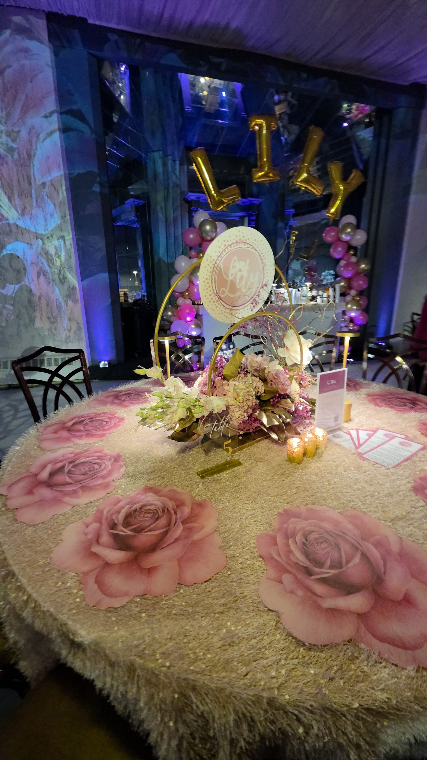 A table with a rose projected across it, florals and candles