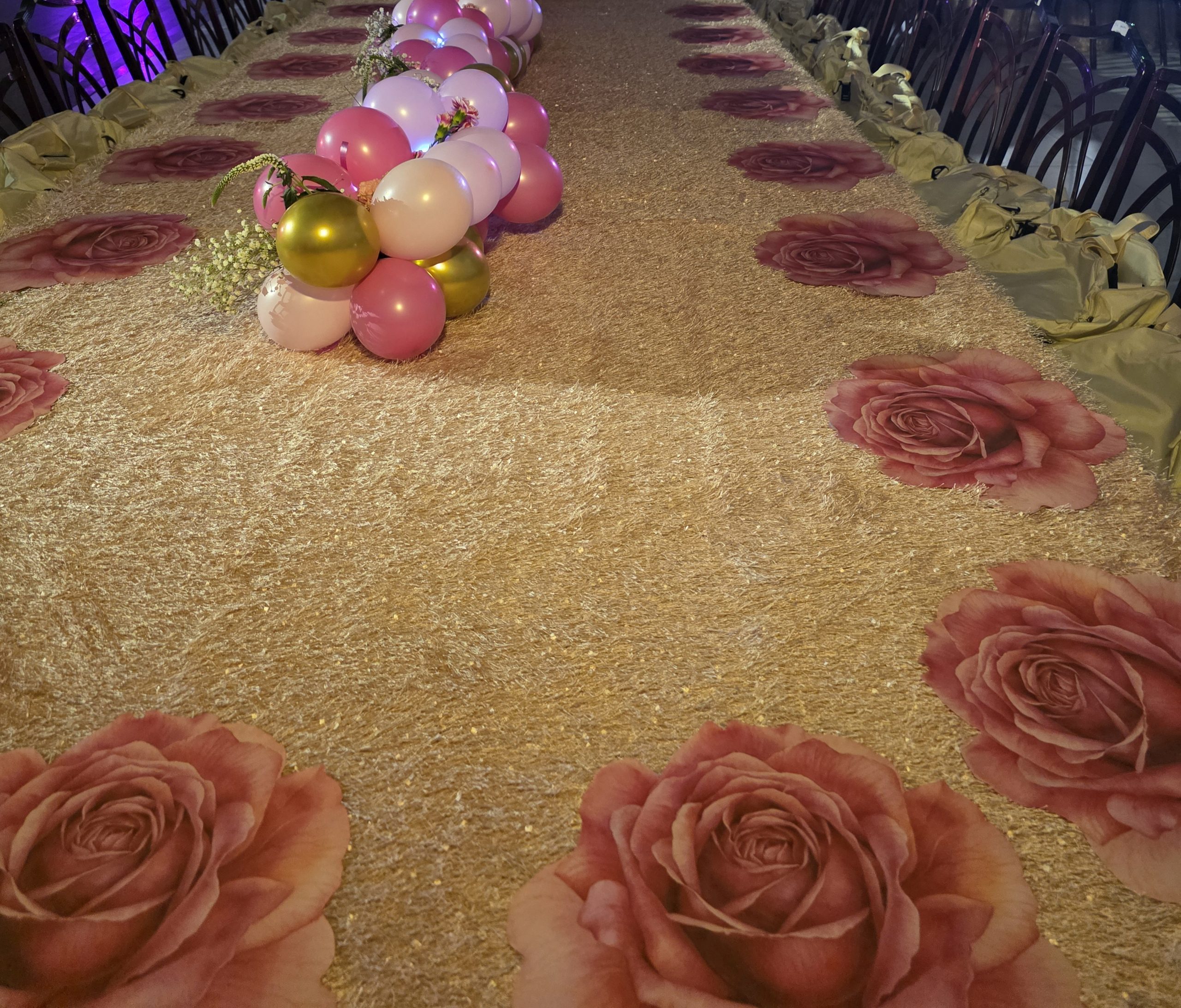 The gold runner with roses projected along it, the tables either side, the lit wall at the end