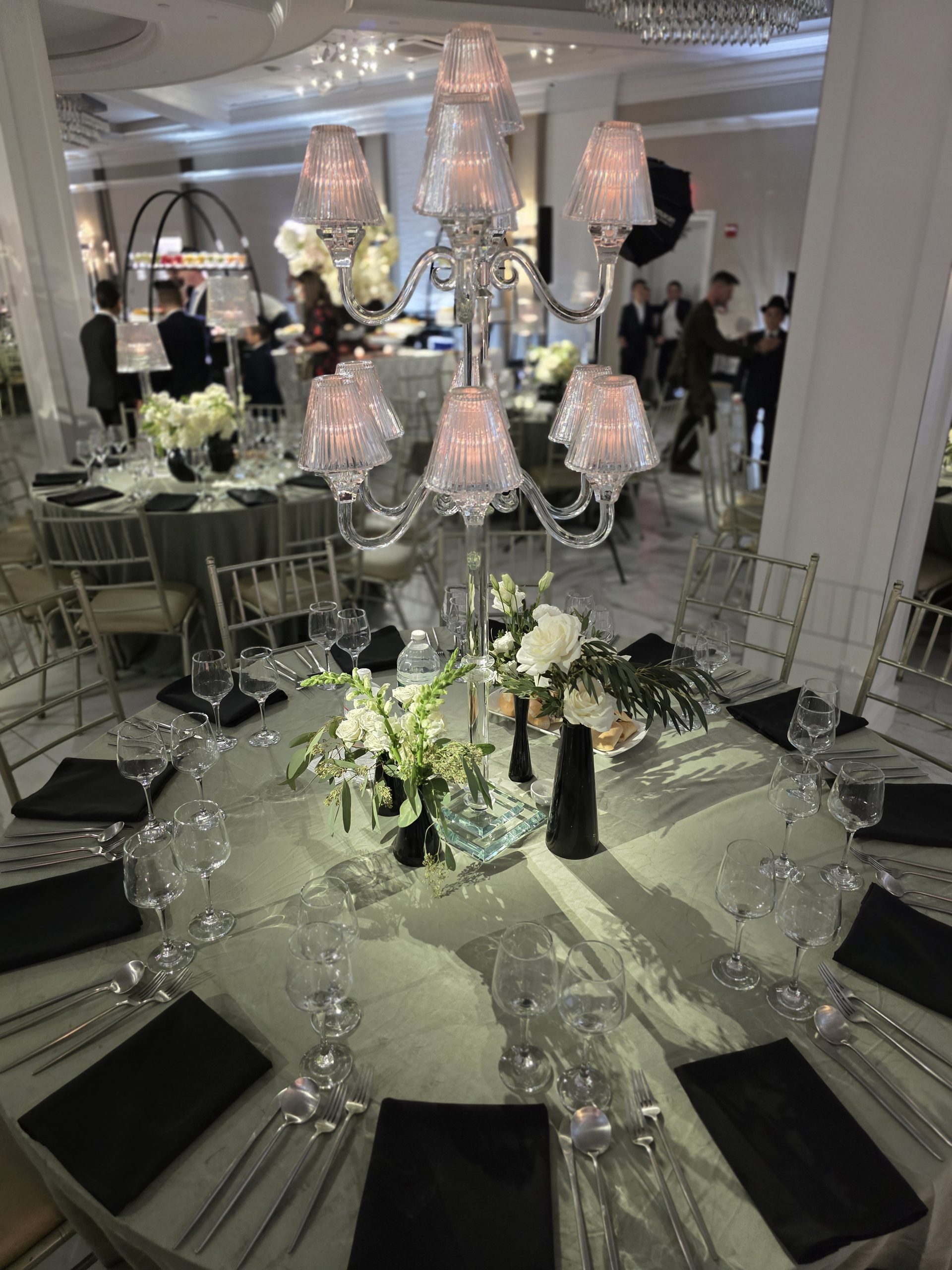The ballroom set: round tables in sage, candelabras on each, the walls washed soft
