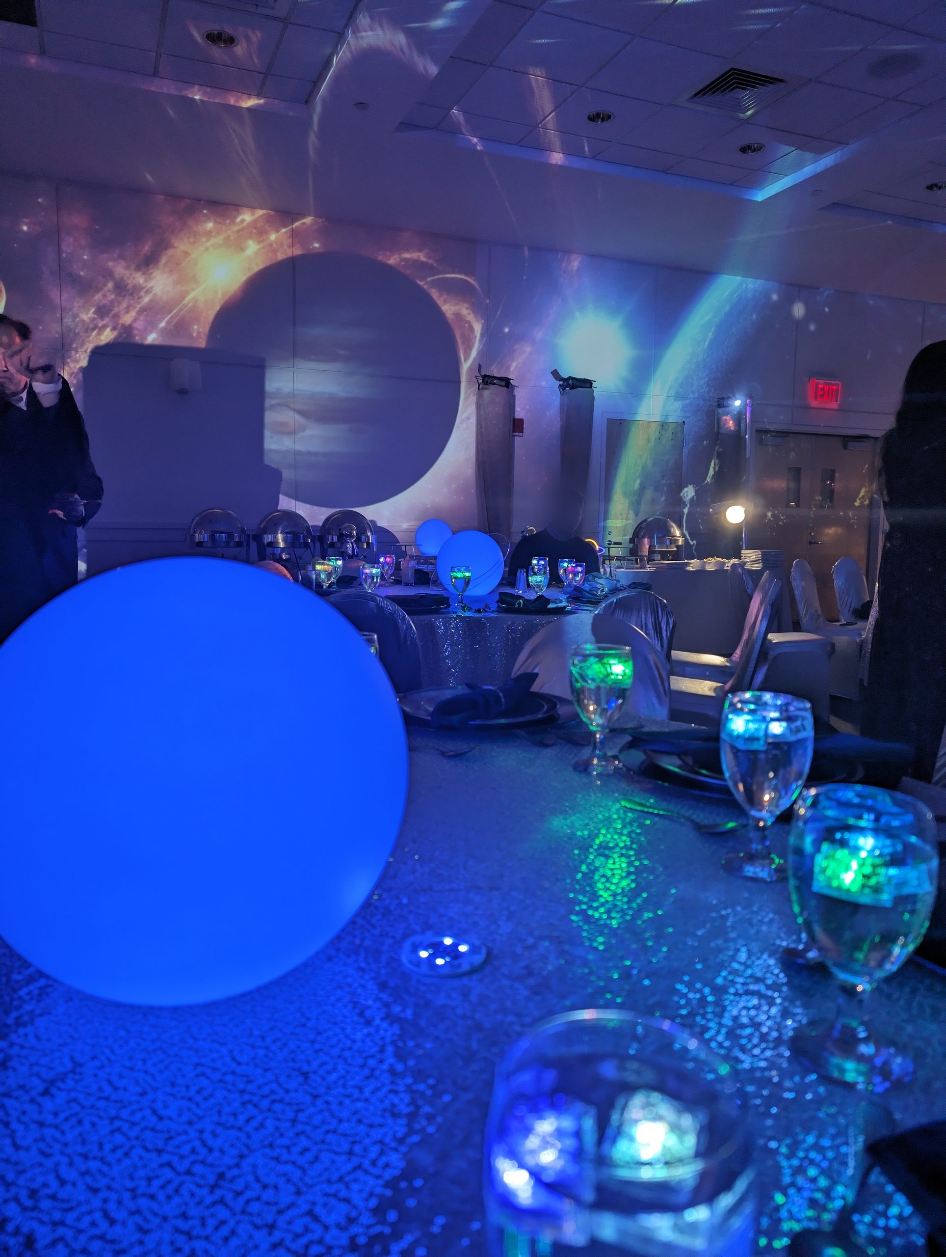 The ring, the glass, the glow: a ringed planet above a lit table
