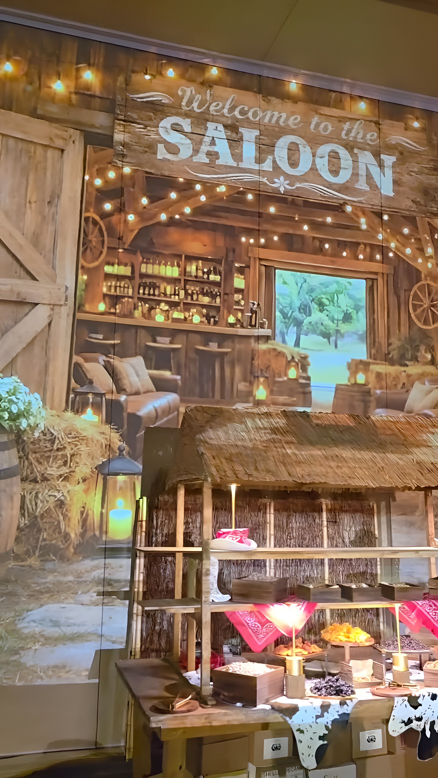 Welcome to the Saloon — the projected bar wall over the sweets table
