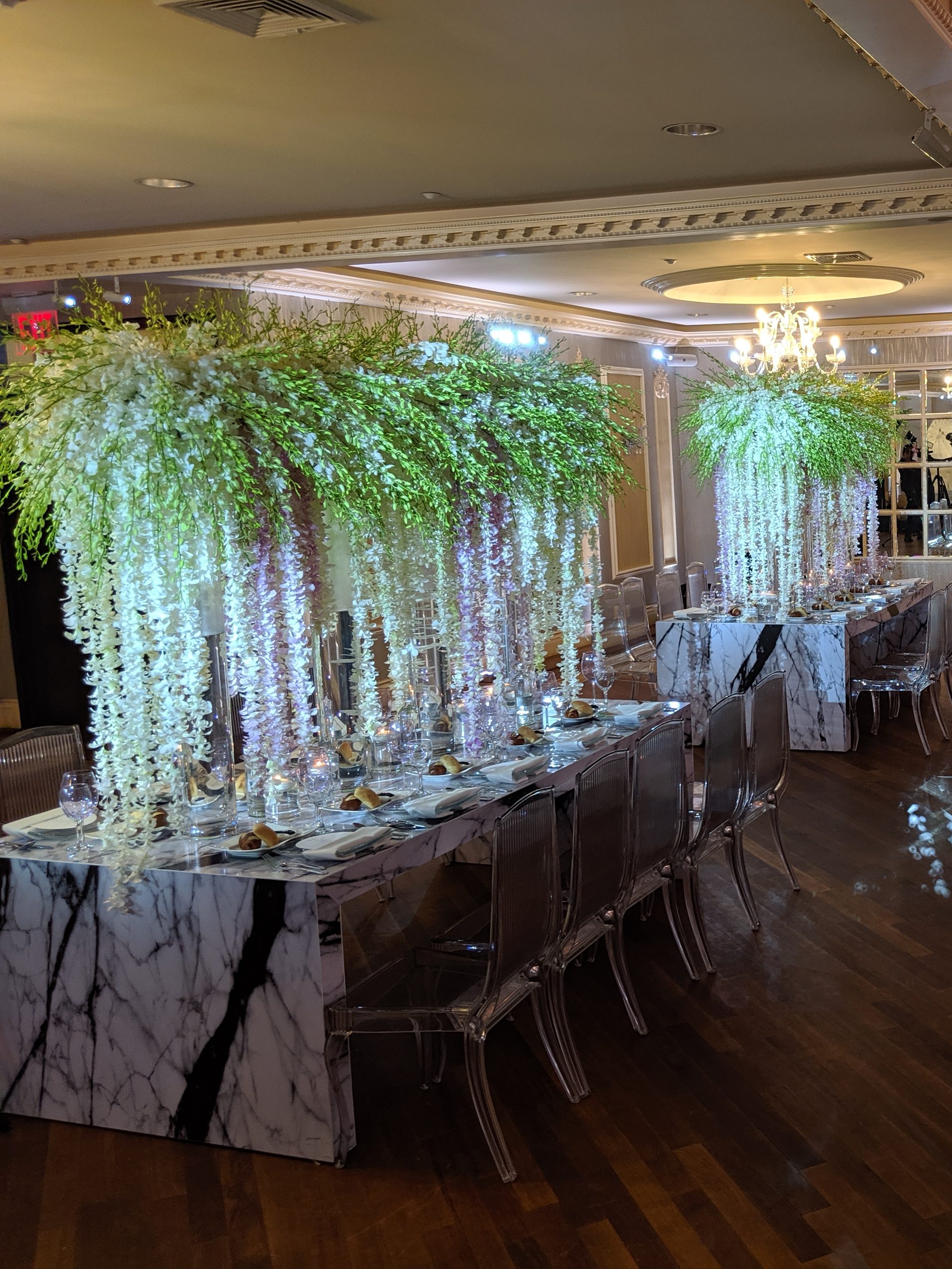 The wisteria canopy over the long tables, the lit tapers and the chandeliers, the room washed white