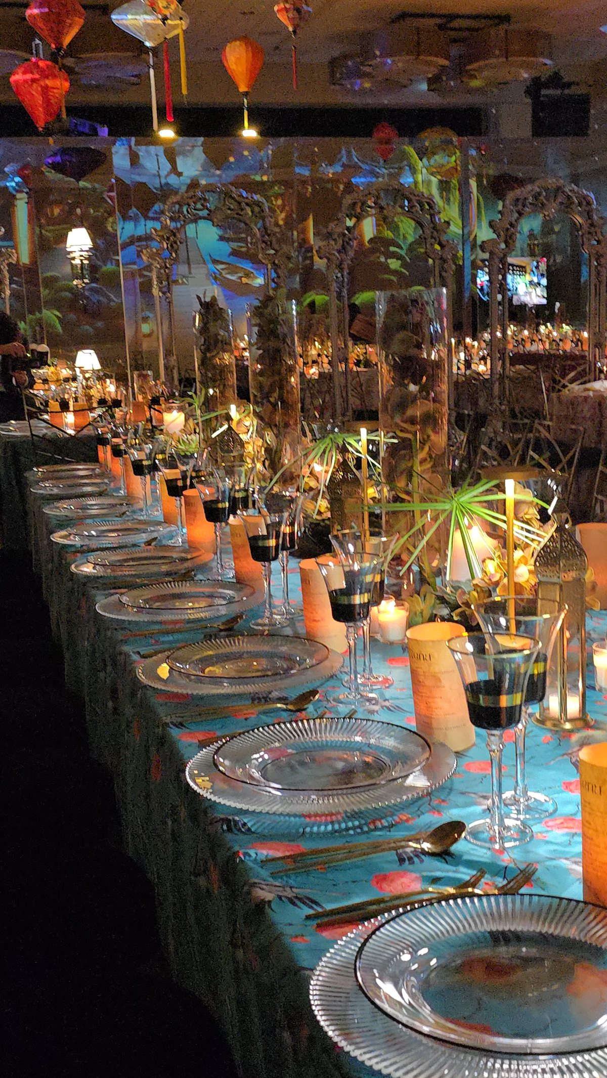 A long table of amber candles and glass, the room lit low