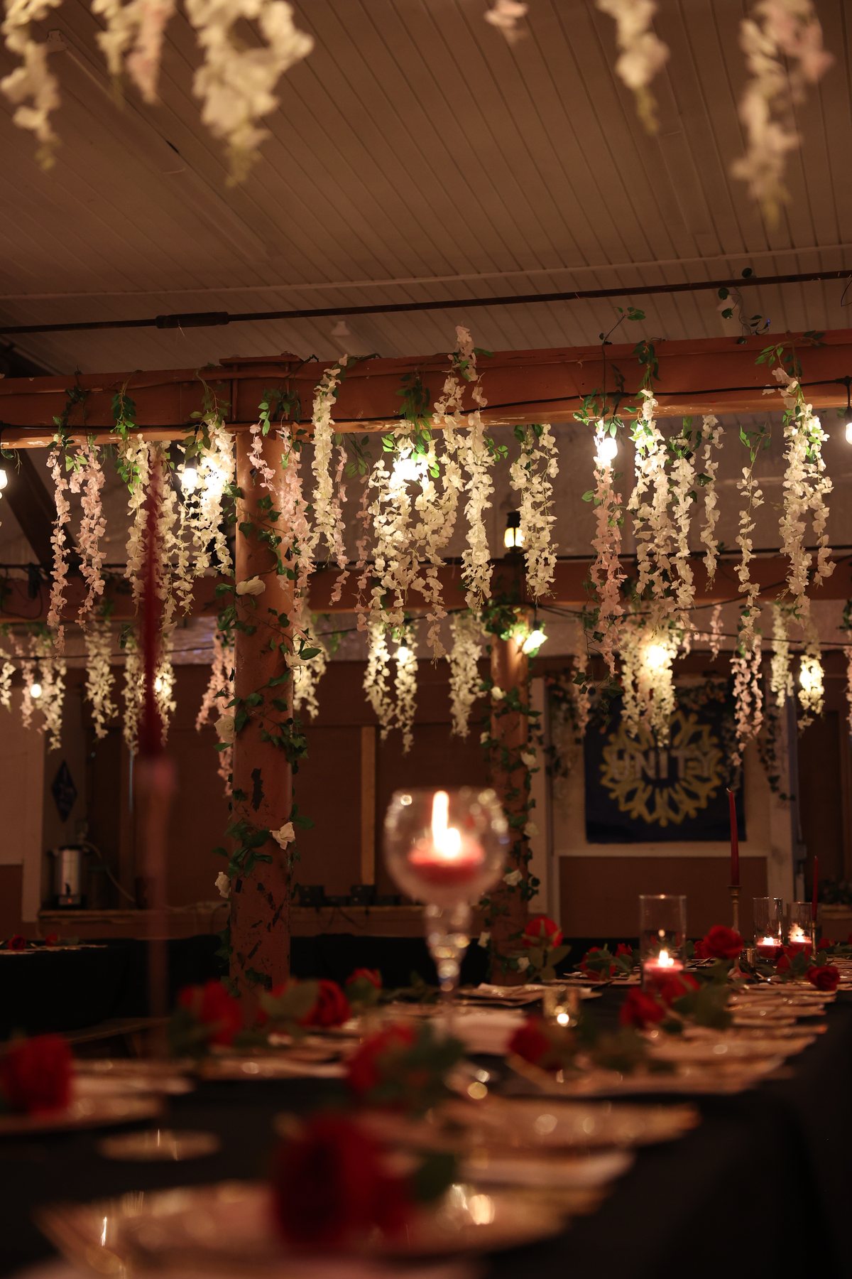 Wisteria and warm light hanging over the set tables