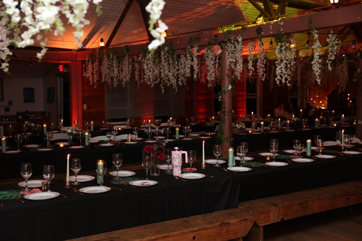 The wisteria hall at night, long tables set in black