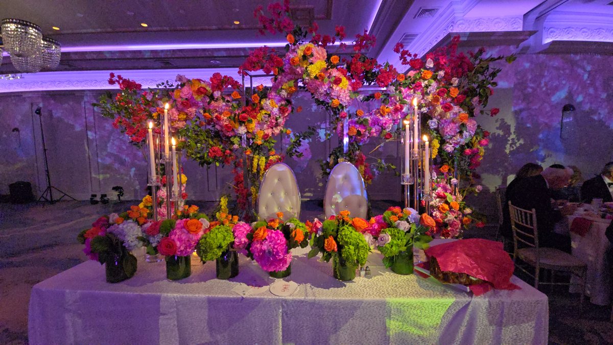 Bright mixed florals and candles on the head table