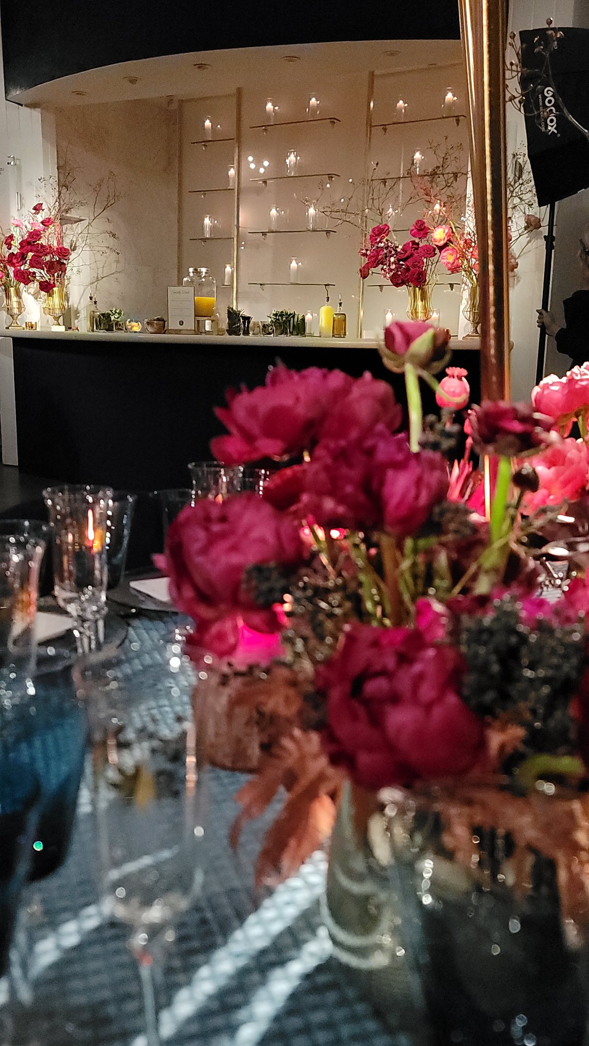 Red peonies massed on a mirrored table