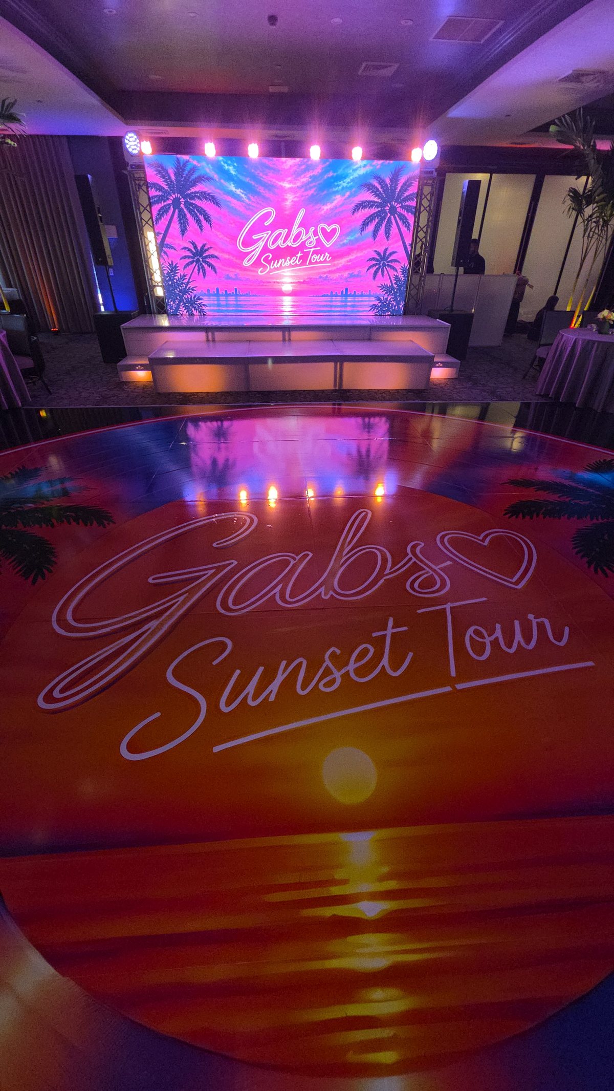 A name and a sunset projected across the dance floor and stage